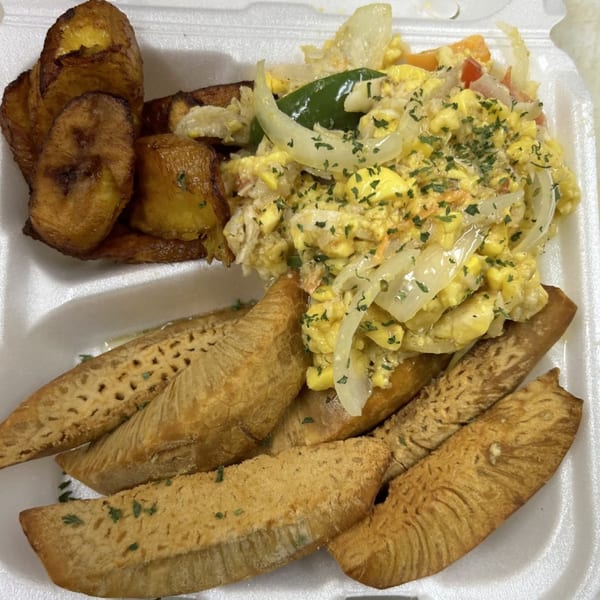 Island Flavors' Jamaican breakfast with scrambled eggs, plantains, and fried breadfruit in a takeout container.